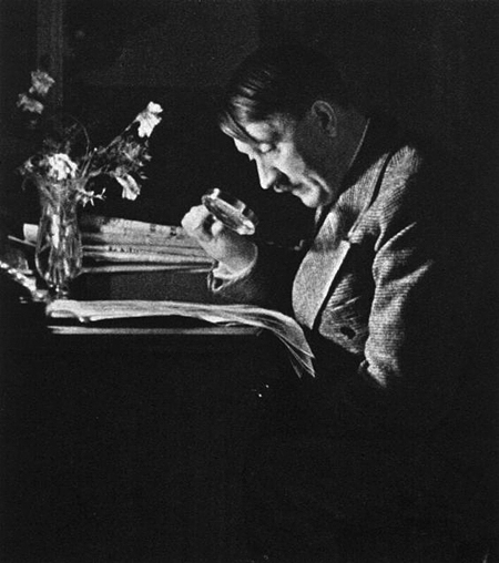 Adolf Hitler reads a newspaper with a magnifying glass in Haus Wachenfeld
